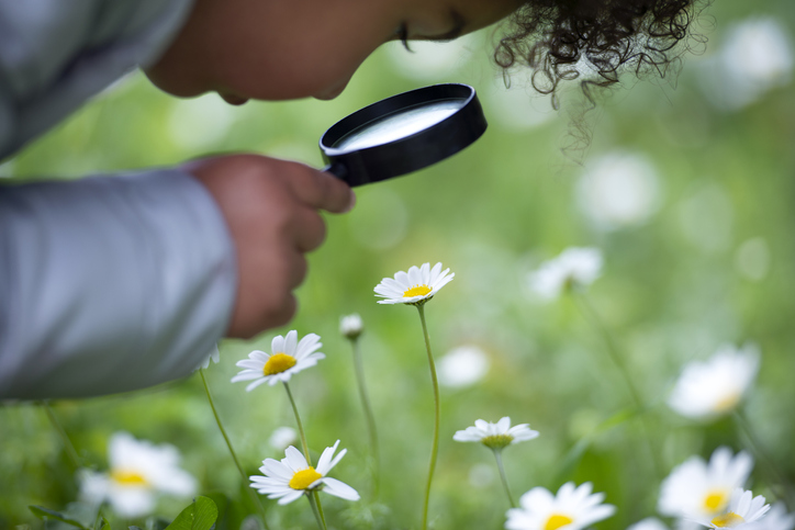 student with magnifying glass