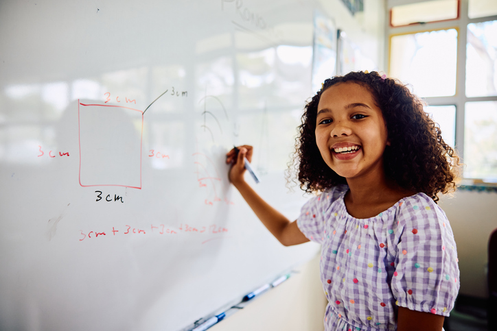 Student writing on whiteboard