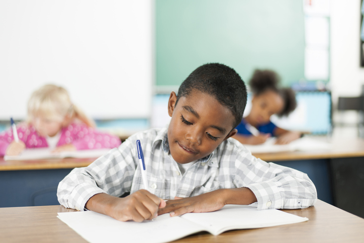student writing at desk